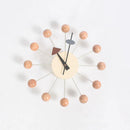 The Clock, background wall, wall clock showcases European style with a beige face and black hands. Twelve light brown spheres are evenly spaced with thin rods, accented by a red triangle and blue circle for decorative flair—ideal for sophisticated interiors.