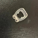 A small, translucent plastic nose clip, named the Silicone Magnetic Anti Snore Stop Snoring Nose Clip Sleep Tray Sleeping Aid Apnea Guard Night Device, rests on a dark textured surface with round ends designed to grip the sides of the nose for effective anti-snore assistance.