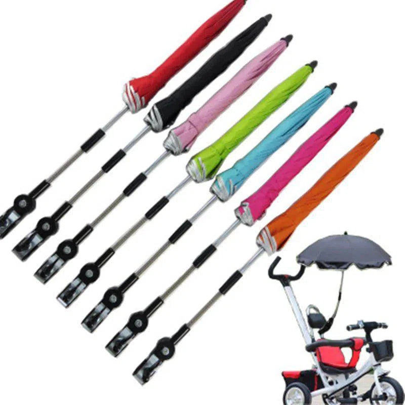 Seven vibrant 360 Degrees Pram Umbrellas in red, pink, black, gray, light pink, blue, and orange are displayed above a baby tricycle with a gray adjustable stroller umbrella. These chic accessories promise style and practicality for every outing.