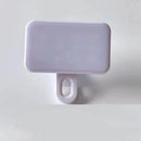 The Mini Selfie Fill Light features a rectangular white LED design with rounded edges, adjustable 3 color modes, rechargeable battery, and a clip-on base for mounting on phones or computers, shown on a plain white background.