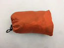 An orange sleeping bag with a black drawstring, similar to the Automatic Quick-Opening Mosquito Net Hammock for camping, rests on a white surface.