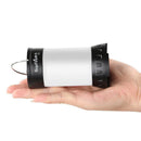 A small, cylindrical Camping Lights Outdoor Multi-function LED Rechargeable Super Bright Tent Light rests on an open palm. With black ends and a white side displaying the SupFire brand, this lantern has a top metal loop, perfect for hanging during camping adventures.