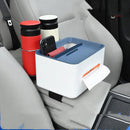 The Car Sundries Storage Cup Drink Mobile Phone Armrest Box Tissue Box with a blue lid sits on the cars gray armrest, holding a phone and tissues. Next to it, two travel mugs—one red and one off-white—are snug in their cup holders.