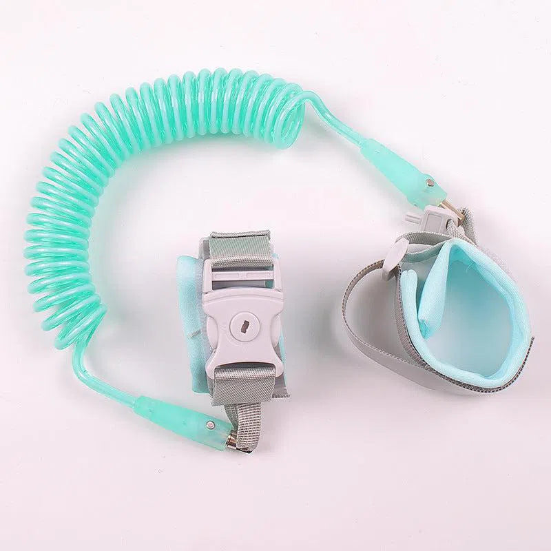 The Child Safety Wristband in turquoise includes adjustable gray and light blue wristbands joined by a coiled cord. Designed with anti-slip Velcro, plastic buckles, soft padding for comfort, and 360-degree free rotation, it ensures enhanced safety.