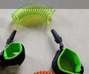 The Child Safety Wristband, a green coiled leash with black and green anti-slip velcro wrist straps, lies on a light gray surface. Engineered for child safety or sports, it offers 360-degree free rotation for ultimate freedom of movement.