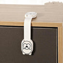 The Child safety lock, featuring a cartoon bear face design, is attached to the corner of a wooden cabinet. Its white strap securely connects two parts, keeping the cabinet doors safely closed and child-proof.