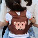 An adult holds a child using the Child safety rope motorcycle child safety belt, ensuring security. The child wears a monkey-themed backpack harness with a smile and bow tie, paired with a white shirt with orange trim and denim shorts, while the adult matches with a white shirt.