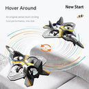 Two black and gray Childrens Remote Control Aircraft V17 Fighter Drones, shaped like jets, hover above a sofa. Colorful trails suggest motion as these foam gliders perform stunts, promoting hand-eye coordination. Text reads Hover Around and New Start.