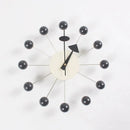 The Clock is a modern European-style wall clock featuring a minimalist design with a white central face, two black hands, and 12 black spheres connected by thin rods in a sunburst pattern, ideal for any interior on a crisp white background.