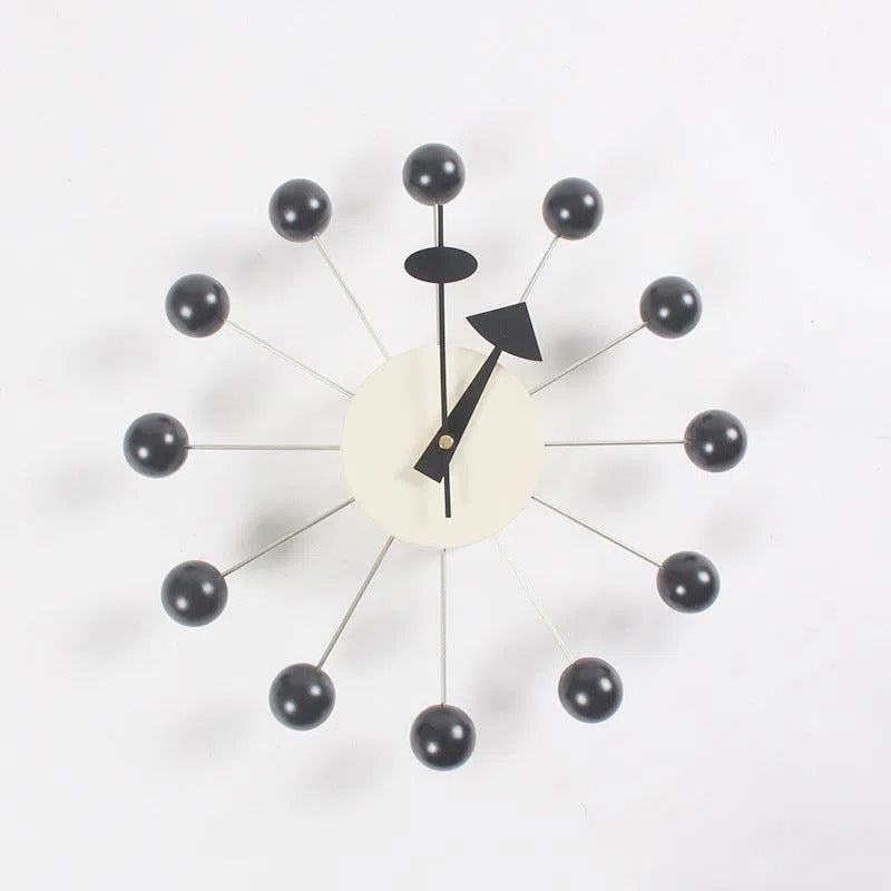The Clock is a modern European-style wall clock featuring a minimalist design with a white central face, two black hands, and 12 black spheres connected by thin rods in a sunburst pattern, ideal for any interior on a crisp white background.