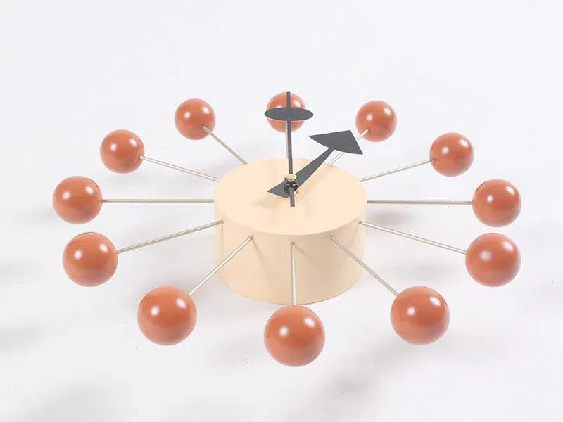 The Clock, background wall, wall clock showcases a minimalist European style with a beige circular face and black hands. Its twelve orange spheres connected by rods resemble an atomic structure, ideal for modern interiors.