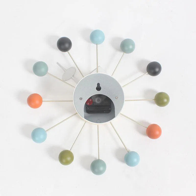 The Clock, background wall, wall clock showcases colorful spherical markers in blue, orange, green, black, and gray. Its open face design blends minimalist and artistic elements to elevate any rooms interior effortlessly.