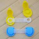 On a wooden surface, two child safety locks, one yellow and one blue, are shown with a non-toxic design. Each lock includes a flexible white strap connecting two circular ends; one end is open to display the Door lock safety lock for childrens anti-opening door mechanism.