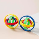 Two Fingertip Gyro Creative Leisure Inertia Rotation toys, crafted from interlocking rings in yellow, red, green, and blue concentric circles, rest on a light surface and a piece of paper. Perfect as stress-relief gadgets with vibrant colors that catch the eye.