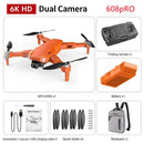 This image displays the GPS High-definition Dual Camera drone in orange, designed for aerial photography with a 6K HD camera and GPS 608S system. Included are a folding remote, battery, USB cable, spare blades, screwdriver/manual, and a carrying bag.