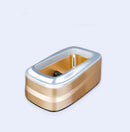 The Household Simple Automatic Shoe Cover Machine is a gold and silver rectangular device with a metallic shine, sleek design, and rounded edges. It features durable construction and a hollow center against a plain white background.