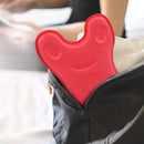 A red device labeled LOCYOP NECKANGEL peeks from an open black bag. Its an Innovative Neck Stretcher Neck Massager for cervical spine pain relief. In the background, a blurred person is partially visible near a bed.