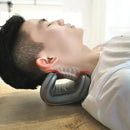 A person in a white shirt rests on the Innovative Neck Stretcher Neck Massager, with an overlay illustrating cervical spine alignment. A softly lit background enhances the sense of comfort and effective pain relief.