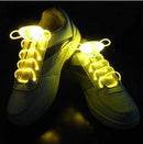 A pair of white sneakers featuring Led Sport Shoe Laces Glow Shoe Strings, set against a dark background, highlighting their vibrant illumination.