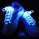 Displayed in a dark setting, the Led Sport Shoe Laces Glow Shoe Strings create a striking contrast against white sneakers with their fiber-optic technology and glowing LED effect, adding an eye-catching flair to any outfit.