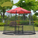A red Mosquito Net Outdoor Patio Umbrella Net Cover Roman Umbrella encircles a round table on stone pavement, creating an ideal outdoor relaxation space amidst vibrant green trees and shrubs under a clear sky.