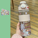 A hand holds the Portable Large Capacity Plastic Cup—a clear water bottle with a pink lid and central grip. Its adorned with cute rabbit and bear stickers against a green backdrop, perfect for stylish hydration.