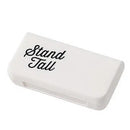 The Portable pill storage box is a white rectangle featuring Stand Tall in elegant black cursive on its smooth surface, cleverly doubling as a travel pill organizer.
