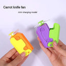 Two hands hold vibrantly designed Radish Knife Mini-portable Handheld Fans resembling box cutters. One fan is orange and yellow, the other is purple and green. Each has small propellers protruding. Text reads Carrot knife fan and mini charging model.