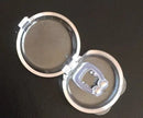 A small, transparent plastic case with a clear lid reveals the Silicone Magnetic Anti Snore Nose Clip, designed for a peaceful nights sleep with its soft pads and apnea guard features, elegantly resting on a dark surface.