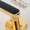 A close-up of The Smart Door Lock Opens At A Touch shows its sleek, modern design with a golden finish and black accents. It features fingerprint storage, a small button, and a USB port on a white surface with gold text and WiFi symbols.