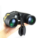 A hand holds a pair of Waterproof Binocular Coordinate Ranging Telescopes in black with a camouflage pattern. They feature large green-tinted lenses, attached lens caps, and the model number 8X42 on top, highlighting their impressive specifications.