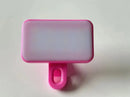 The Mini Selfie Fill Light features 3 color modes, adjustable brightness, and a rechargeable design. Its compact pink and white ABS clip with a translucent front clips onto phones or computers—perfect for portable photography lighting.